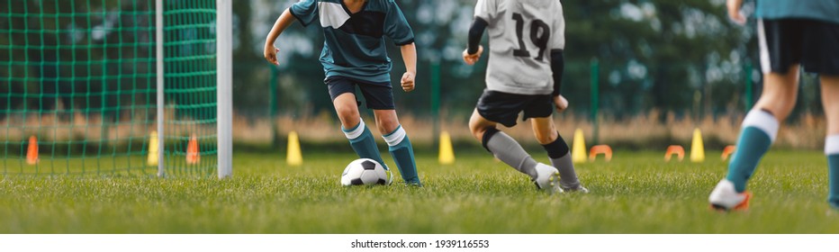 Soccer Players On Training Pitch. Group Of Young Footballers In A Duel. Soccer Kids Running Ball In A Practice Match. School Kids Playing Game On Summer Training Camp