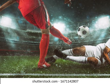 Soccer Scene At The Stadium With Player In A Red Uniform Kicking The Ball And Opponent In Tackle To Defend