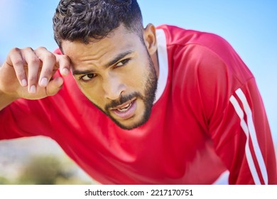 Soccer, sports and tired young athlete at a game, training or workout on an outdoor field. Fitness, exercise and healthy man player taking breathe while playing football match on pitch at the stadium - Powered by Shutterstock