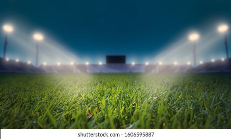 Soccer Stadium with Green Grass Field with Bright Floodlight Background.lights at night and football stadium