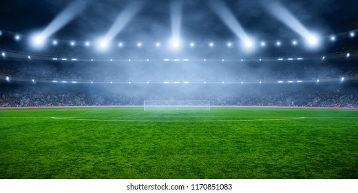 Soccer stadium with illumination, green grass and night  blurred sky