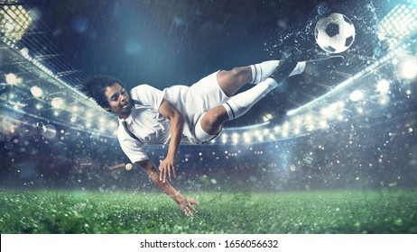 Soccer striker hits the ball with an acrobatic kick in the air at the stadium - Powered by Shutterstock