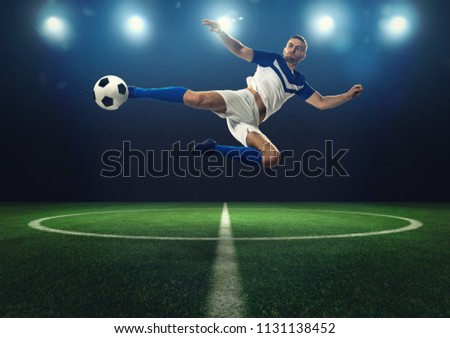 Soccer striker hits the ball with an acrobatic kick