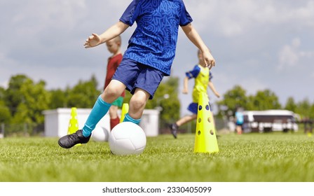 Soccer Summer Camp For School Kids. Young Player Kicking Ball in Practice Drill. Youth Football Team Improving Skills During Football Training Session - Powered by Shutterstock