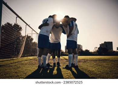 Soccer, sunset or team in a huddle for motivation, goals or group mission on stadium field for a sports game. Match, sunshine or football players planning a strategy, exercise or training for fitness - Powered by Shutterstock