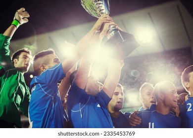 Soccer team celebrating with trophy on field - Powered by Shutterstock