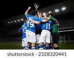 Soccer team cheering with trophy on field