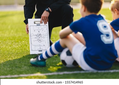 Soccer Team Meeting. Coach Giving Tactic Advices Using Football White Board. Coaching Youth Sports Team