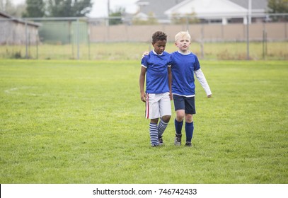 Soccer teammates consoling each other after a tough loss on a soccer field. Concept photo of encouragement from friends after disappointment from a loss