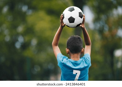 Soccer Throw In During Children Sports Game. Little Boy Holding Soccer Ball in Hands. Kids Playing in Football League. Boy in Soccer Blue Jersey With Number Seven  - Powered by Shutterstock