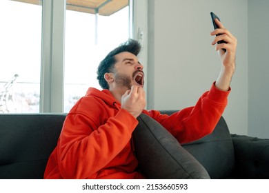 Soccer Watcing, Young Man Watching Soccer Match On His Phone And Getting Very Excited, He Makes A Gesture With His Hand And Opens His Mouth With Excitement