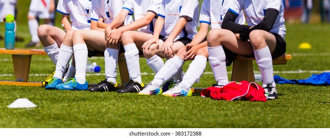 Soccer Youth Team; Reserve Players On A Bench; Boys With Football Coach