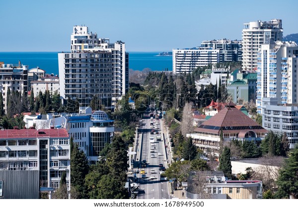 Sochi, Russia - 01.05.2019 Tall\
houses. Central Street. Resort Avenue. View of the sea. Downtown.\
It\'s a sunny day. Sochi. City resort. Stay. South of\
Russia.