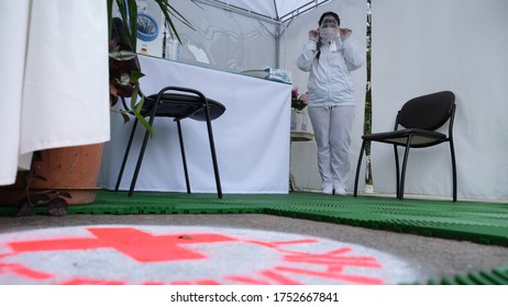 Sochi, Russia - 06.01.2020 A Masked Nurse. Ambulance. A Woman In A White Robe. The Red Cross. Covid 19