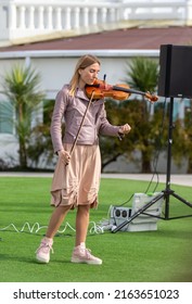 Sochi, Russia - February 22, 2022:A Woman Plays The Violin On The Street In A Resort Town.