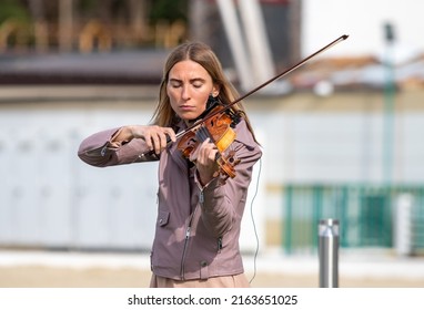 Sochi, Russia - February 22, 2022:A Woman Plays The Violin On The Street In A Resort Town.