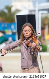 Sochi, Russia - February 22, 2022:A Woman Plays The Violin On The Street In A Resort Town.