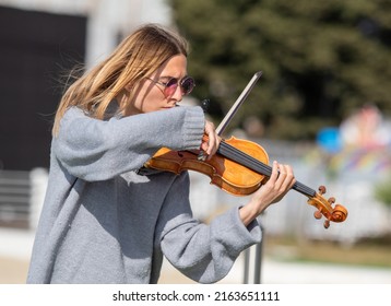 Sochi, Russia - February 22, 2022:A Woman Plays The Violin On The Street In A Resort Town.