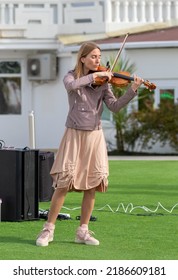 Sochi, Russia - February 22, 2022:A Woman Plays The Violin On The Street In A Resort Town.