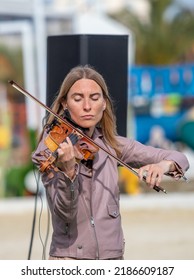 Sochi, Russia - February 22, 2022:A Woman Plays The Violin On The Street In A Resort Town.