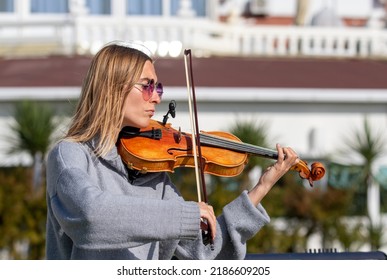 Sochi, Russia - February 22, 2022:A Woman Plays The Violin On The Street In A Resort Town.