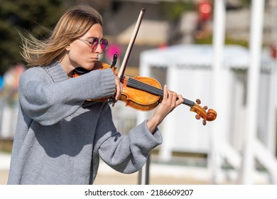 Sochi, Russia - February 22, 2022:A Woman Plays The Violin On The Street In A Resort Town.