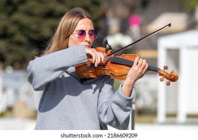 Sochi, Russia - February 22, 2022:A Woman Plays The Violin On The Street In A Resort Town.