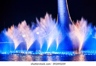 SOCHI, RUSSIA - MARCH 1, 2016: Crowds of tourists watching at a bowl of the Olympic flame "Firebird" and singing Fountain in the Olympic park in the evening