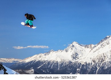 Sochi, Russia - March 25, 2014: Quiksilver New Star Camp Is The Most Large-scale Sports And Entertainment Mountain Camp For Ski And Snowboard Riders In Russia. A Male Snowboarder Is Flying From A Jump