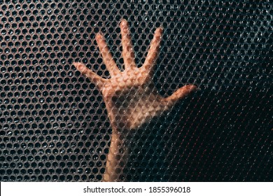 Social Anxiety. Panic Attack. Nervous Breakdown. Fear Tense. Desperate Insecure Woman Hand Trying To Find Way Out Trapped Behind Plastic Bubble Wrap Textured Wall In Darkness.