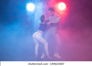 Social dance, bachata, salsa, kizomba, zouk, tango concept - Man hugs woman while dancing over lights