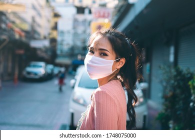 Social distance and new normal lifestyle virus protect at outdoor area concept. Happy asian adult woman tan skin wear mask on face. Background chinatown landmark destination. Bangkok, Thailand.