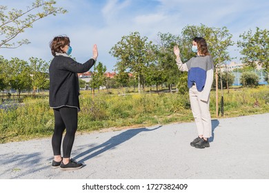 Social Distance. Two Neighbors Walk Through A Park And Greet Each Other While Keeping Their Distance From The Pandemic. Pandemic. Coronavirus Devices. Coronavirus. Covid-19.