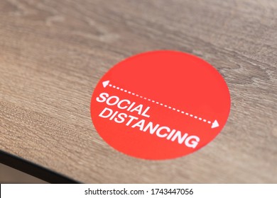 Social Distance Word Sticker On The Table In Restaurant.Social Distancing Instruction Against The Spread.New Normal Reopen Mall, School.Social Distancing In The Workplace During Coronavirus COVID-19.