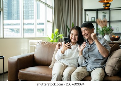 Social Distancing Or New Normal Concept.Happy Asian Family Multi Generation Parent, Grandparent And Daughter Talk On Video Call Online, Webcam Chat On Laptop, Quarantine At Home New Lifestyle