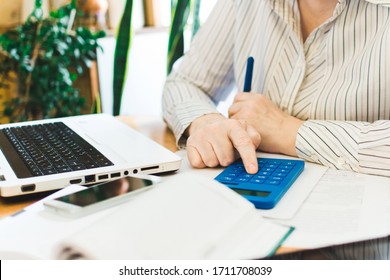 Social distancing protect coronavirus or covid-19. Closeup woman touching blue calculator. Female working in workplace at home. Accountant works remotely. Online education and distance work concept