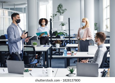 Social distancing in public place, disease prevention during quarantine, staff safety. Meeting and reporting on project or team building by employees and boss in office interior with devices - Powered by Shutterstock