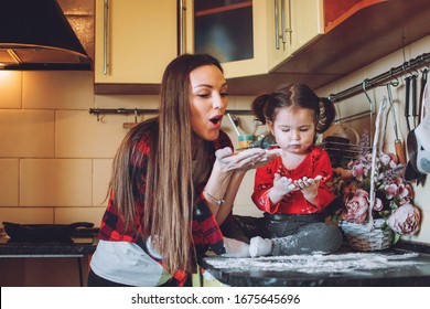 Social Distancing and Self-Isolation, stay home, quarantine, families self-isolating together for Novel Coronavirus COVID-19. Mom and toddler daughter play in the kitchen - Powered by Shutterstock