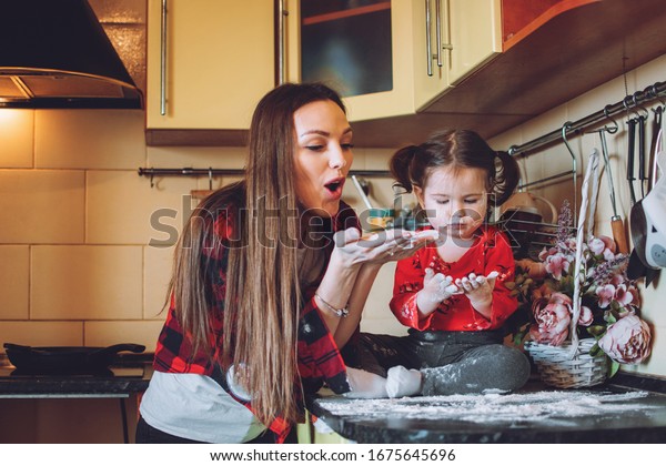 Social Distancing\
and Self-Isolation, stay home, quarantine, families self-isolating\
together for Novel Coronavirus COVID-19. Mom and toddler daughter\
play in the kitchen