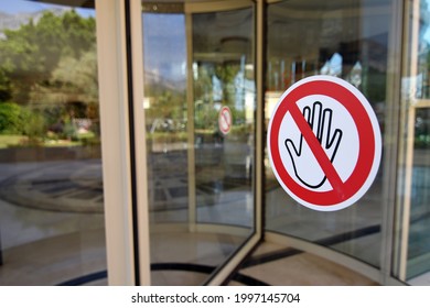 Social distancing sign attached to the revolving door in hotel informing people to keep distance, prevent spreading  COVID-19 virus 