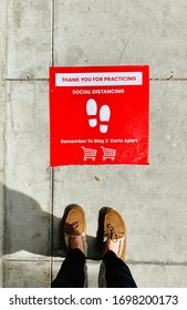 Social Distancing Sign On The Ground At Grocery Store Supermarket During COVID-19 Pandemic Coronavirus Outbreak