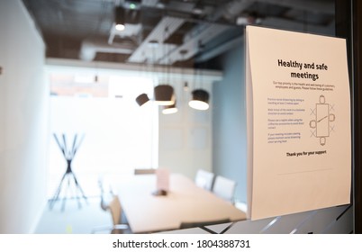 Social Distancing Sign On Meeting Room Door With Meeting Room In Background