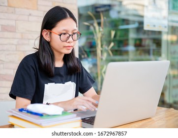 Social Distancing Student Concept, Junior High School Girl Do Homework At Home With Laptop. Teen Study Home The School Is Closed During Coronavirus Covid-19 And Dust PM2.5 In Bangkok Thailand 