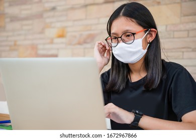 Social Distancing Student Concept, Junior High School Girl Do Homework At Home With Laptop. Teen Study Home The School Is Closed During Coronavirus Covid-19 And Dust PM2.5 In Bangkok Thailand 