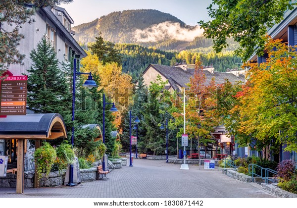 Social distancing in Whistler\
Village in the Fall during Covid 19. Autumn colors on the village\
stroll with Social distancing measures and hand sanitizing\
stations