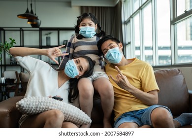 Social Distancing,cheerful Safty,insurance Family,stay At Home And New Normal Lifestyle Concept.Strong Healthy Asian Family Wearing Surgical Protective Face Mask Stay Quarantined Together At Home.