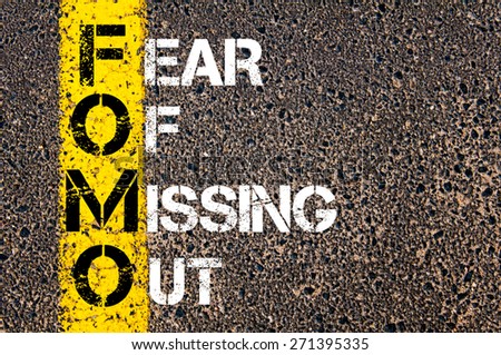 Social Media Acronym FOMO as FEAR OF MISSING OUT. Yellow paint line on the road against asphalt background. Conceptual image