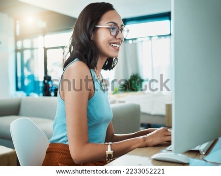 Social media agent with computer browsing online, typing and replying to customer or client emails in home office. Motivated, inspired and smiling creative business woman planning marketing strategy