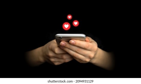 Social media concept. Hands using smartphone with like notification icons. Social networking, black background 