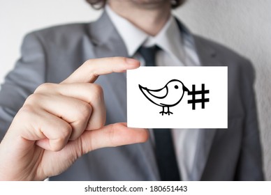 Social media hashtag. Businessman in suit with a black tie showing or holding business card